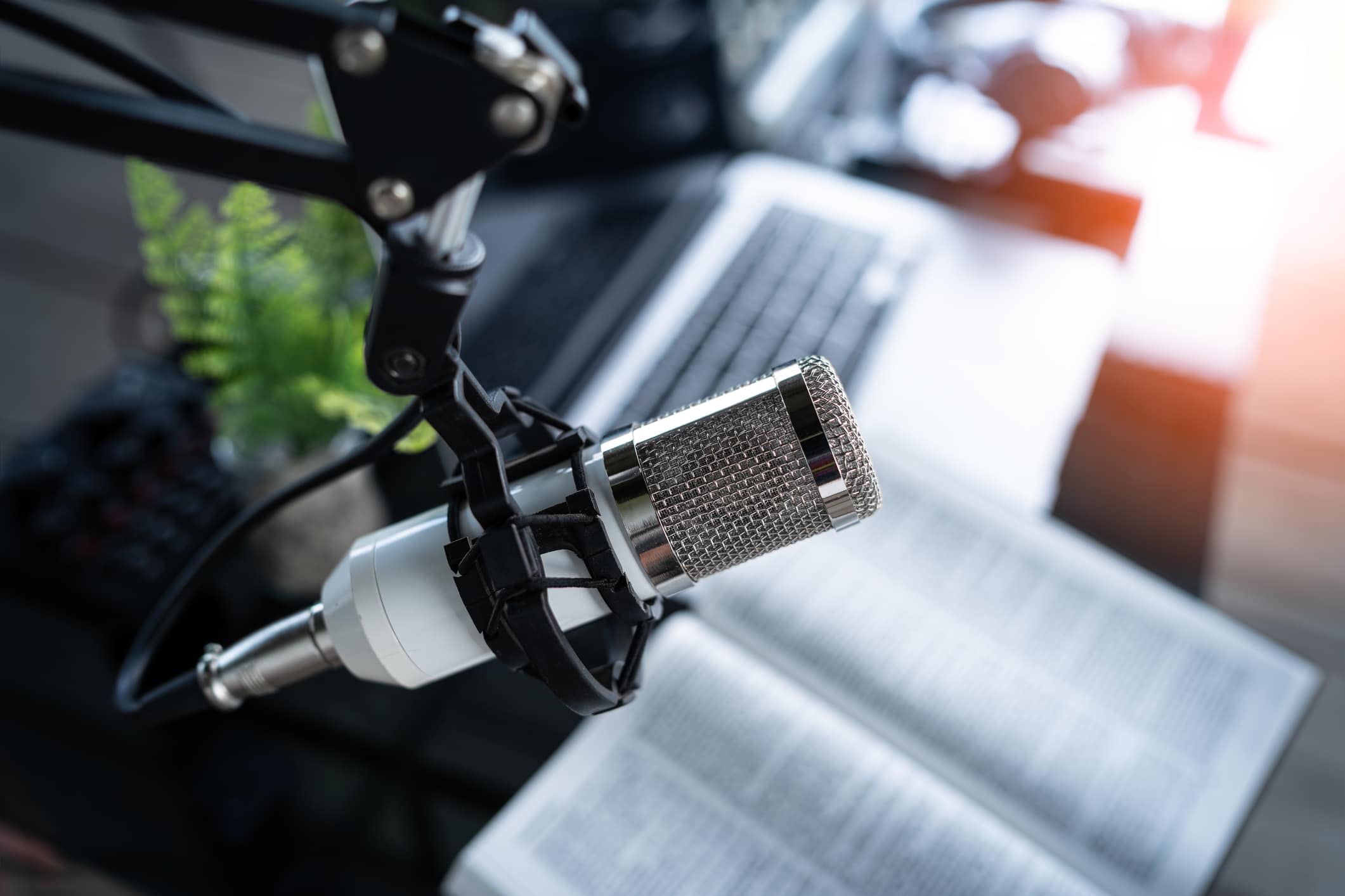 Microphone on desk with Bible, preacher reads the bible online, Christian podcast studio interior, records a podcast, online radio broadcast.